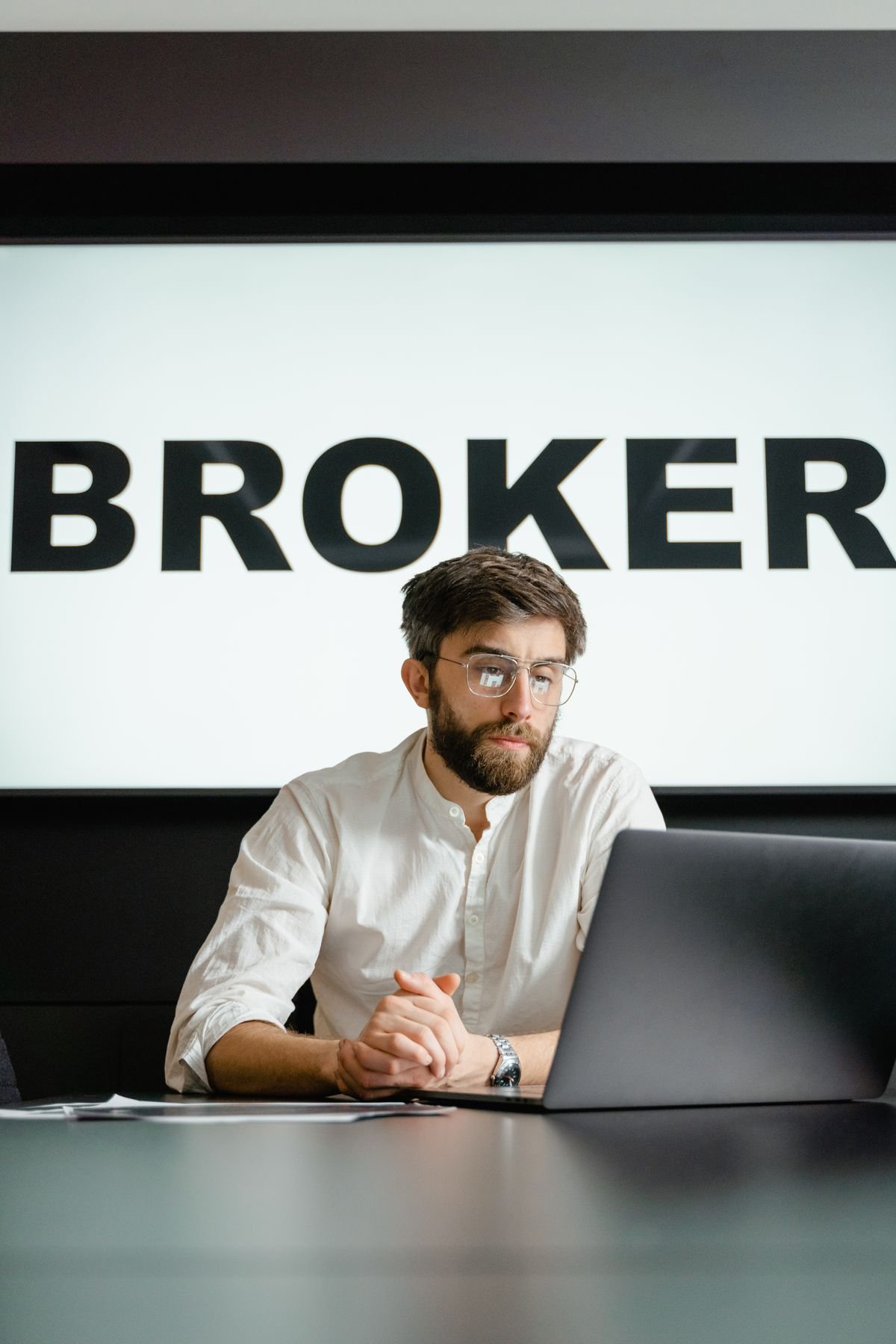 Conseiller en gestion de patrimoine en rendez-vous avec un client autour d'un ordinateur portable