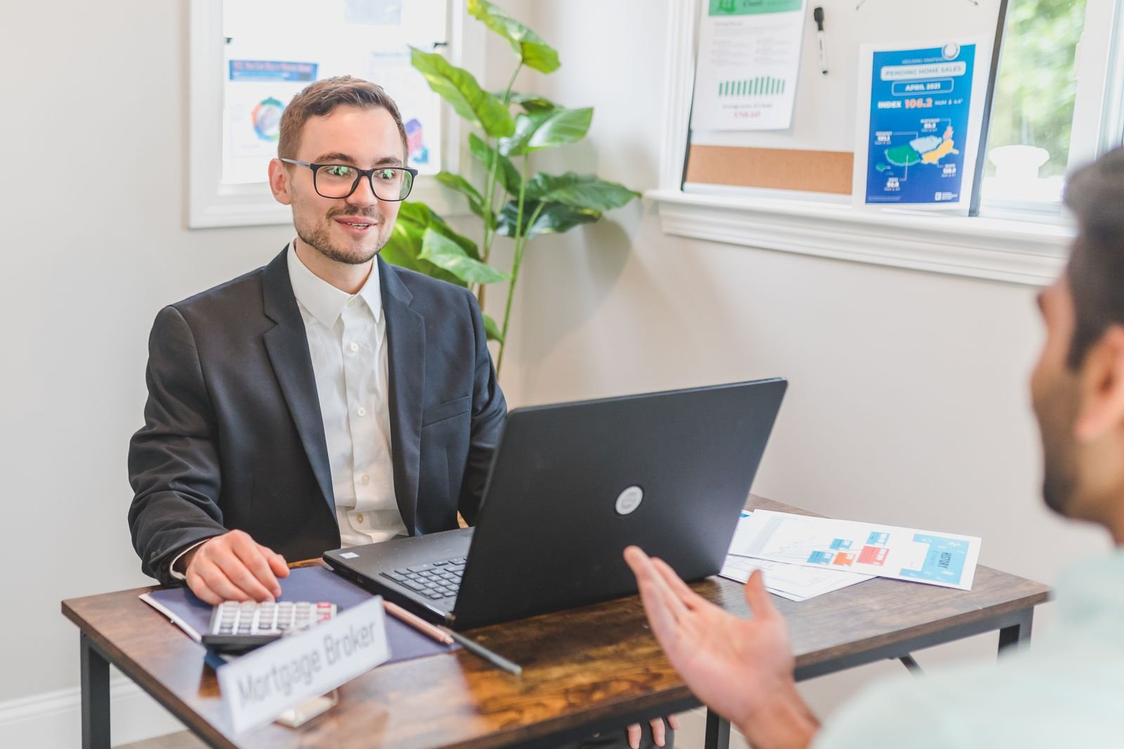Conseiller en gestion de patrimoine calculant les honoraires et frais d'un accompagnement au bureau