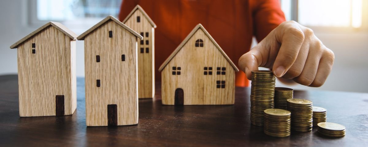 Maquettes de maisons en bois illustrant l'investissement immobilier via les SCPI