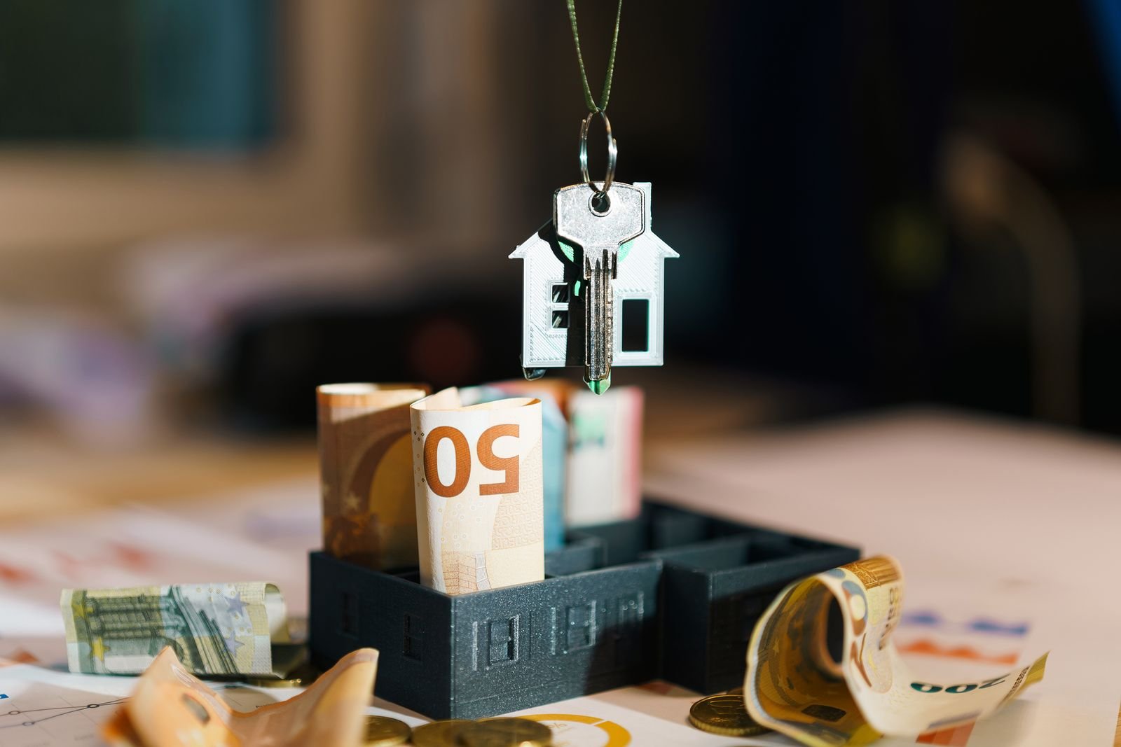 Trousseau de clés de maison posé sur des billets en euros, illustrant un bien immobilier reçu en héritage